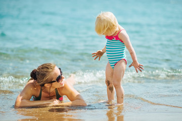 Fototapeta premium Mother and smeared with mud baby on sea beach
