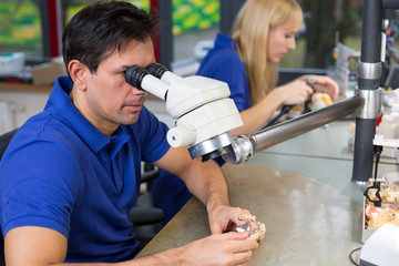 Dental technicians with microscope at work