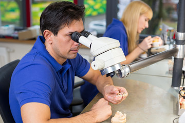 Dental technicians with microscope at work