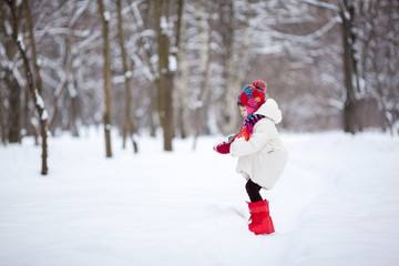 Adorable preschooler girl in beautiful winter park