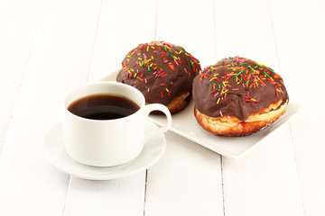 Tasty donuts on color plate on light wooden background