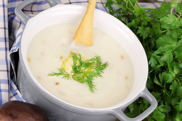 Mashed potatoes in saucepan with ingredients on wooden table