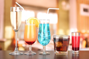 Several glasses of different drinks on bright background
