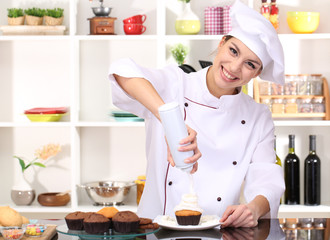 Young woman chef cooking cake in kitchen