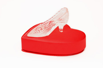 Crystal shoe on a red gift box in heart shape