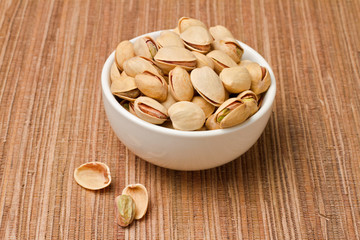 Pistachios nuts in bowl over tablecloth