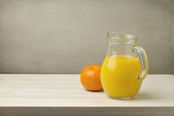 Orange juice with fresh tangerine on white wooden table