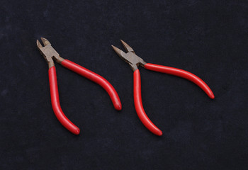 Two kinds of pliers on black background
