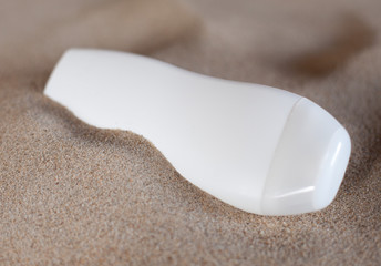 flacon de pommade dans le sable