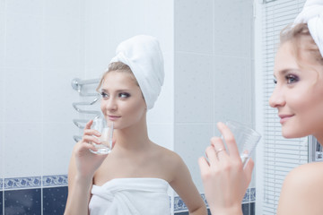 Woman with glass in bathroom