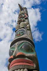 A totem wood pole in the blue cloudy background