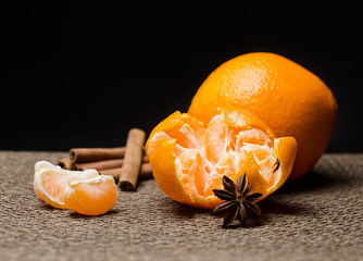 Tangerine, orange, anise and cinnamon against dark background