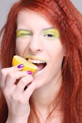 redhaired woman biting the lemon