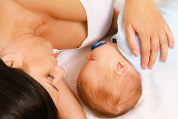 Mother with her baby lying in bed isolated. Top view