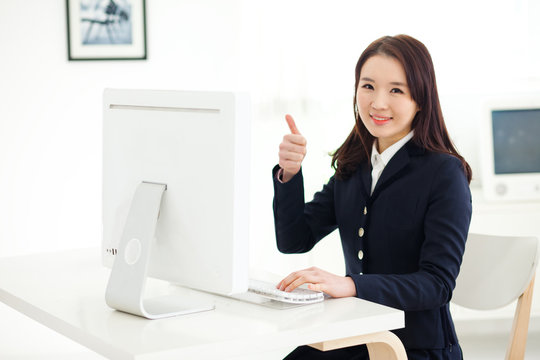 Happy Asian young woman using computer.