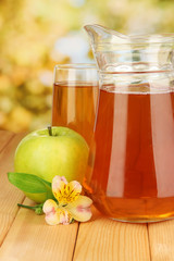 Full glass and jug of apple juice and apple