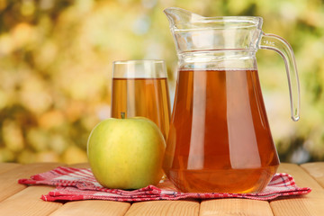 Full glass and jug of apple juice and apple