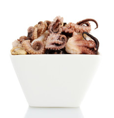 Tentacles of octopus in bowl isolated on white