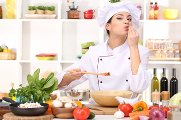 Young woman chef cooking in kitchen