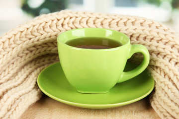 cup of tea with scarf on table in room