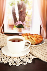 cup of tea with scarf on table in room