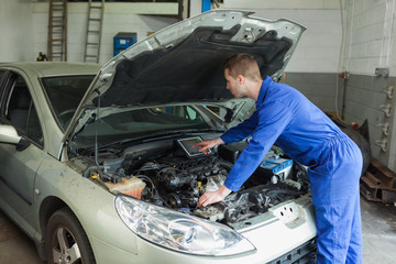 Mechanic examining car engine