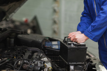 Mechanic changing car battery - 48483786