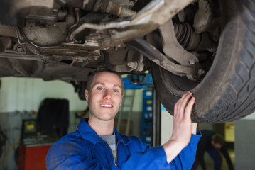 Obraz na płótnie Canvas Male mechanic examining car tire