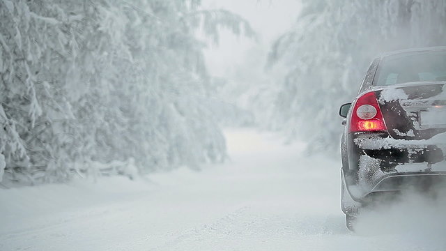Car on winter road with smoke from exhaust pipe