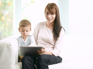 Mother reading a fairy tale to her son from a digital tablet