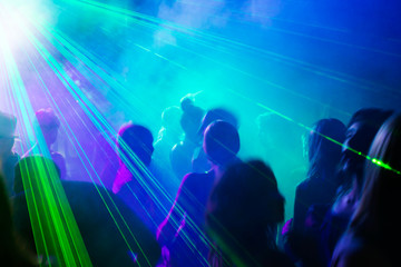 Fototapeta na wymiar Imprezowicze tańczyć pod światłem laserowym.