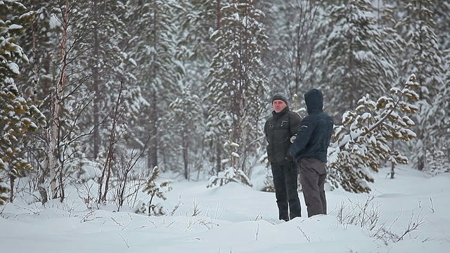 Speaking together in blizzard in winter forest