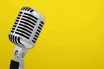 Fototapeta na wymiar Archiwalne mikrofon samodzielnie na żółtym