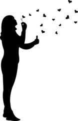 Young girl blowing soap bubbles in heart shaped silhouette