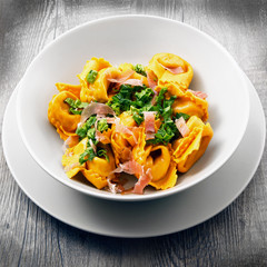 piatto di ravioli con speck e verdura