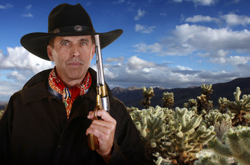 Cowboy with gun touching hat in cholla garden