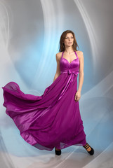 Beautiful young woman in plum violet evening dress