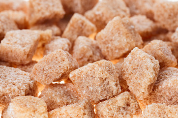 Many brown lump cane sugar cubes , food background