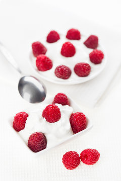 Still life with raspberry sour cream dessert on white linen tabl