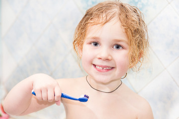 Little girl washing teeth after bath