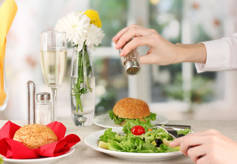 Female hand with  dinner on bright background