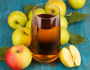 Useful apple juice with apples around on wooden table