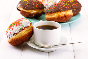 Tasty donuts on color plate on light wooden background