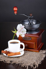 Obraz premium Cup of coffee with coffee mill on wooden table
