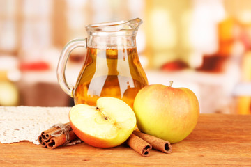 Full jug of apple juice and apple