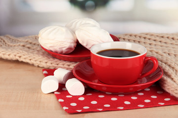 cup of coffee with scarf on table in room