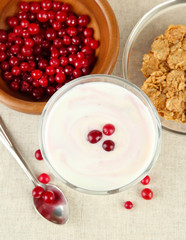 Glass of yoghurt dessert with berries, on tablecloth background