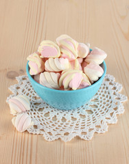 Gentle marshmallow in bowl on wooden table close-up