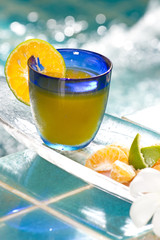 orange juice decorated with orange in blue glass