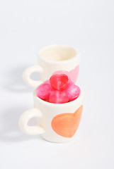 Two cup of love concept with candy in orange cup